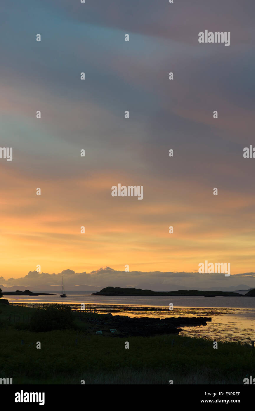 Skyscene de coucher de soleil sur l'bateau de pêche sur le Loch Dunvegan, l'île de Skye en Ecosse Banque D'Images