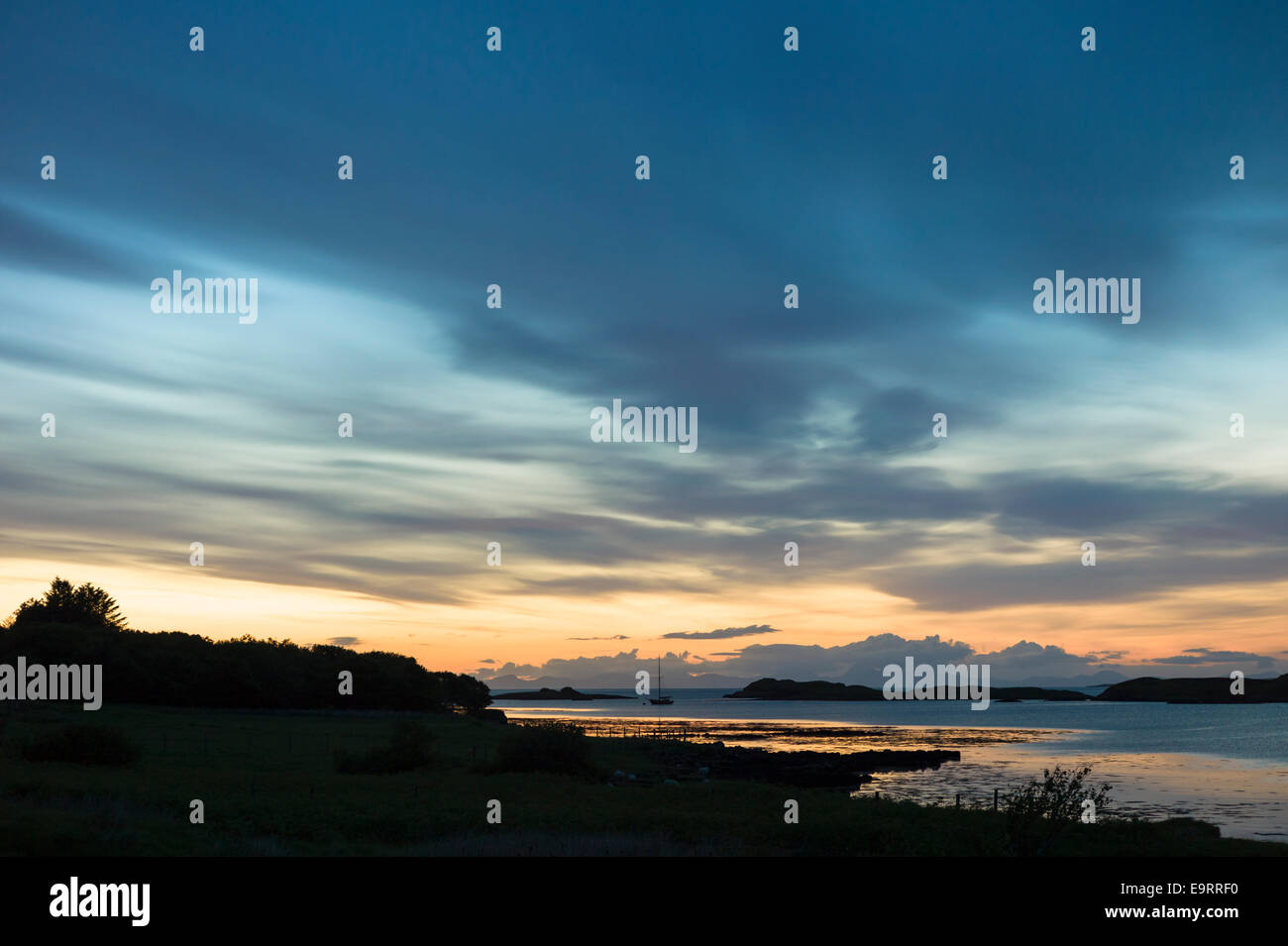 Skyscene de coucher de soleil sur l'bateau de pêche sur le Loch Dunvegan, l'île de Skye en Ecosse Banque D'Images