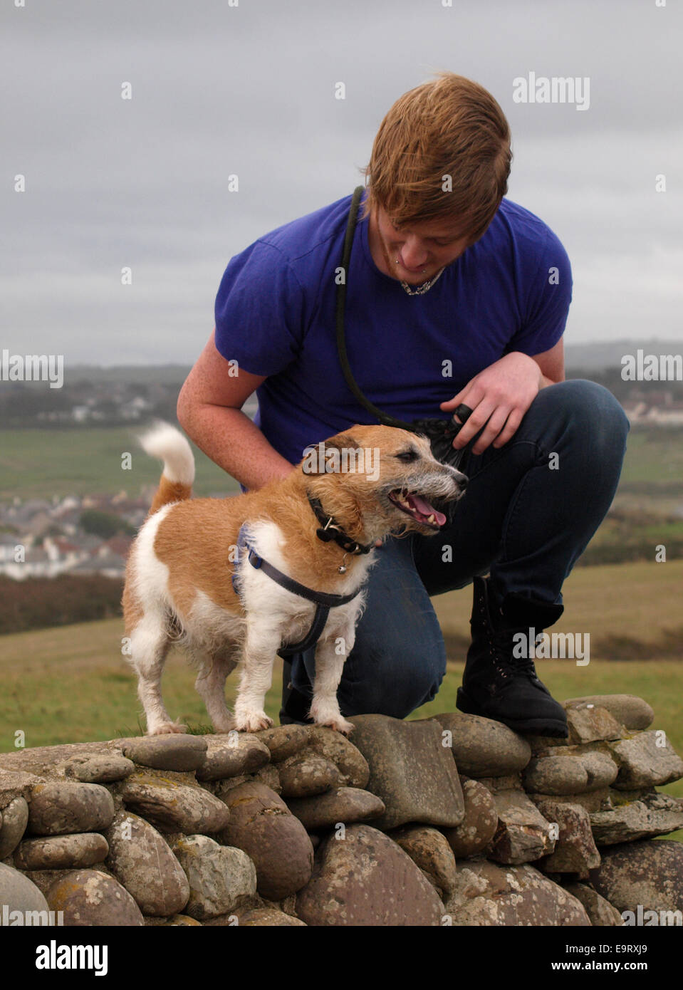 Jeune adulte homme avec son chien Jack Russel, Bude, Cornwall, UK Banque D'Images