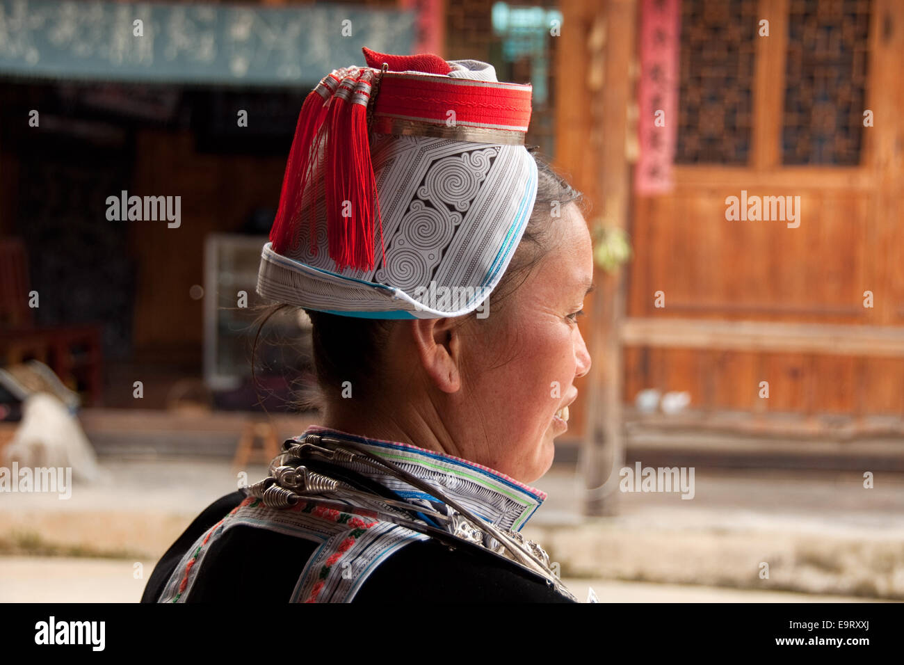 Femme gejia avec coiffe traditionnelle avec orange rouge glands, matang, province de Guizhou, Chine Banque D'Images