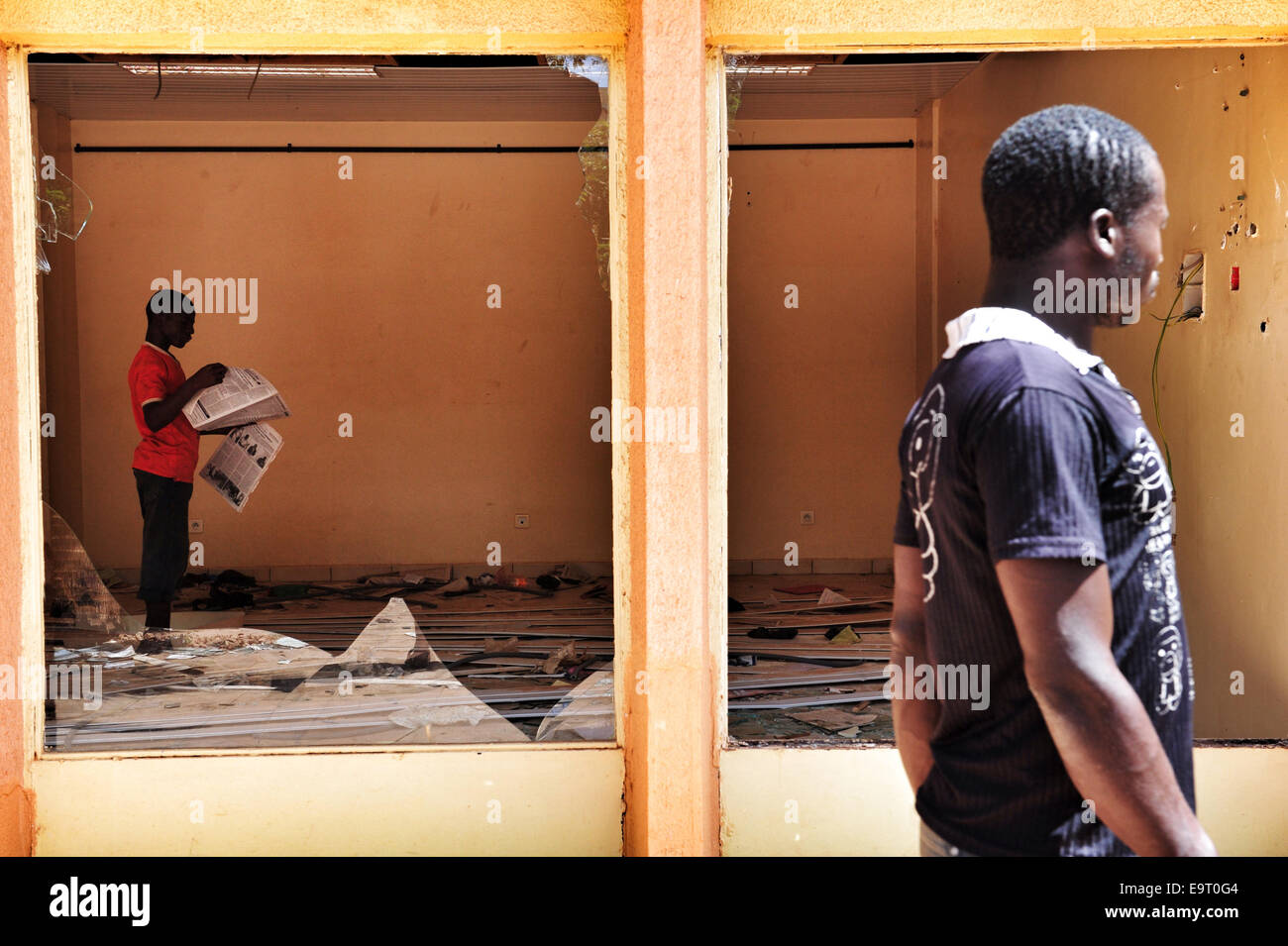 Ouagadougou, Burkina Faso. 1er novembre 2014. Burkina Faso - Les troubles politiques montre un homme lisant un journal à l'intérieur d'un magasin pillé dans le centre de Ouagadougou, deux jours après qu'il a été saccagé par des manifestants en tant que législateurs disposés à voter pour que le Président Blaise Compaoré -- qui a pris le pouvoir dans un coup d'État 1987 -- pour participer aux élections en 2015. Crédit : Alain Fontaine/Alamy Live News Banque D'Images
