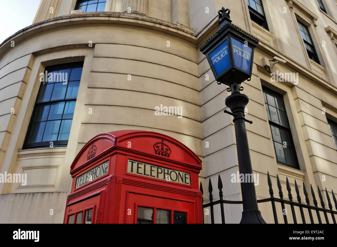 Une boîte de téléphone rouge britannique traditionnel par un vieux lampadaire de la police dans la ville de Londres, Angleterre, Royaume-Uni. Banque D'Images