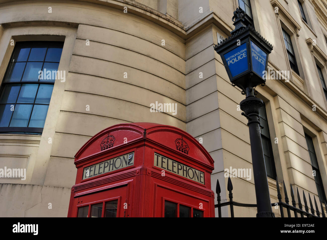 Une boîte de téléphone rouge britannique traditionnel par un vieux lampadaire de la police dans la ville de Londres, Angleterre, Royaume-Uni. Banque D'Images