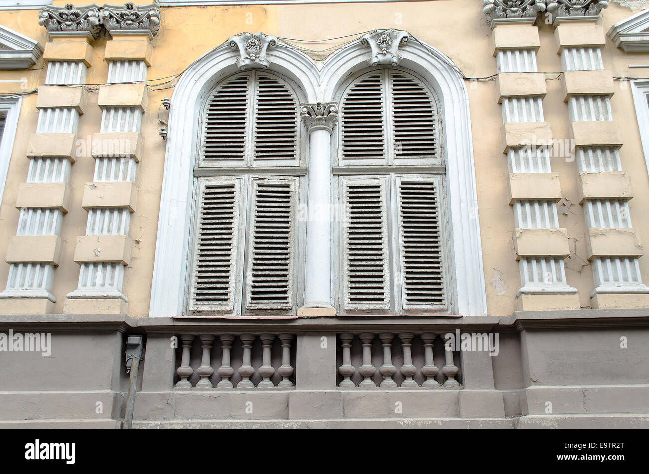 Vieille fenêtre en bois en décomposition sur le mur en ruine en style bulgare Banque D'Images