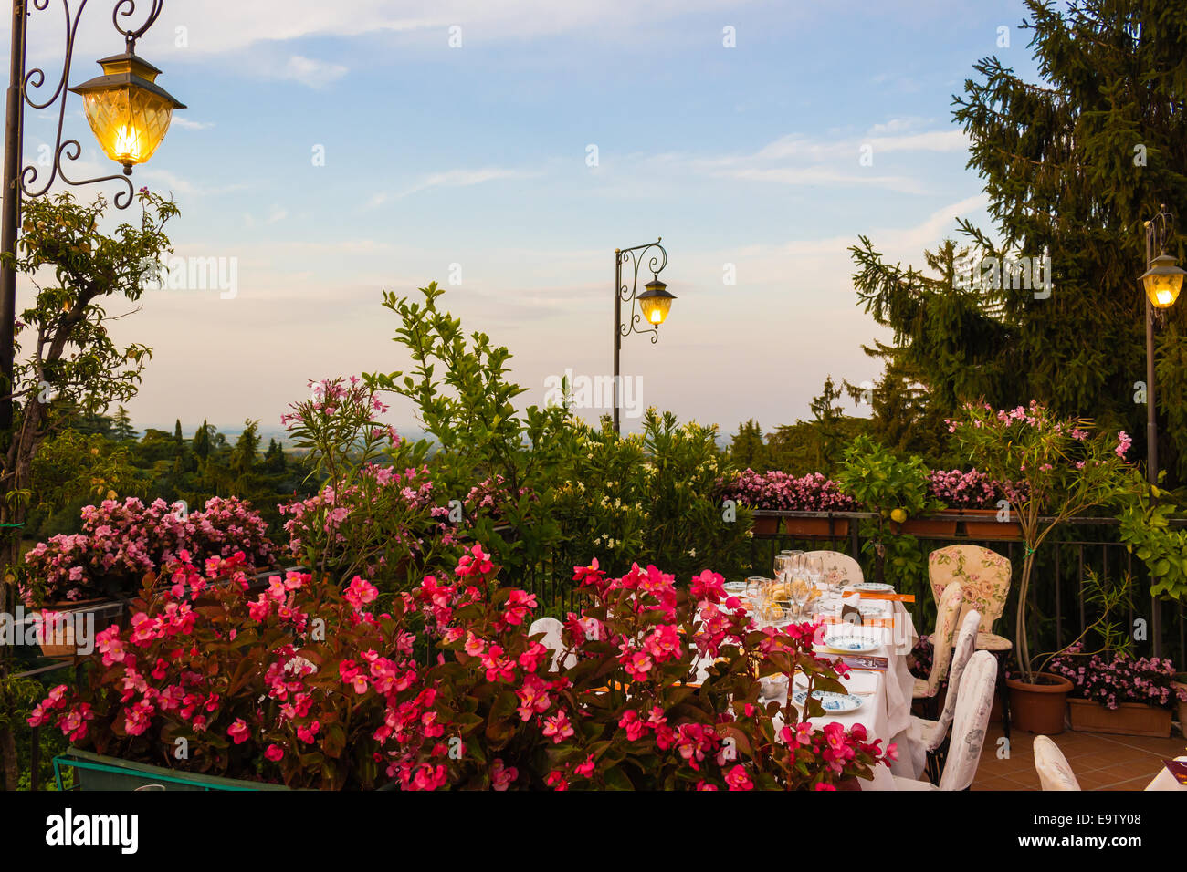 Tables de dîner dans l'élégant restaurant italien de style outdoor sur caillebotis fer parapet sur les collines de Dozza (Bo) en Italie dans une journée ensoleillée d'été : du vrai rouge, jaune et fleurs roses avec des feuilles vertes en pots vert tout autour. Serviettes de table Nappe rose et chic, Banque D'Images Tables de dîner dans l'élégant restaurant italien de style outdoor sur caillebotis fer parapet sur les collines de Dozza (Bo) en Italie dans une journée ensoleillée d'été : du vrai rouge, jaune et fleurs roses avec des feuilles vertes en pots vert tout autour. Serviettes de table Nappe rose et chic, Banque D'Images