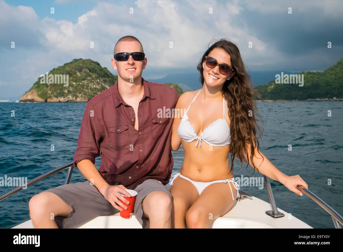 Young couple smiling at camera while sur une excursion en bateau privé à Los Arcos National Marine Park, l'océan Pacifique, de la baie de Banderas Banque D'Images