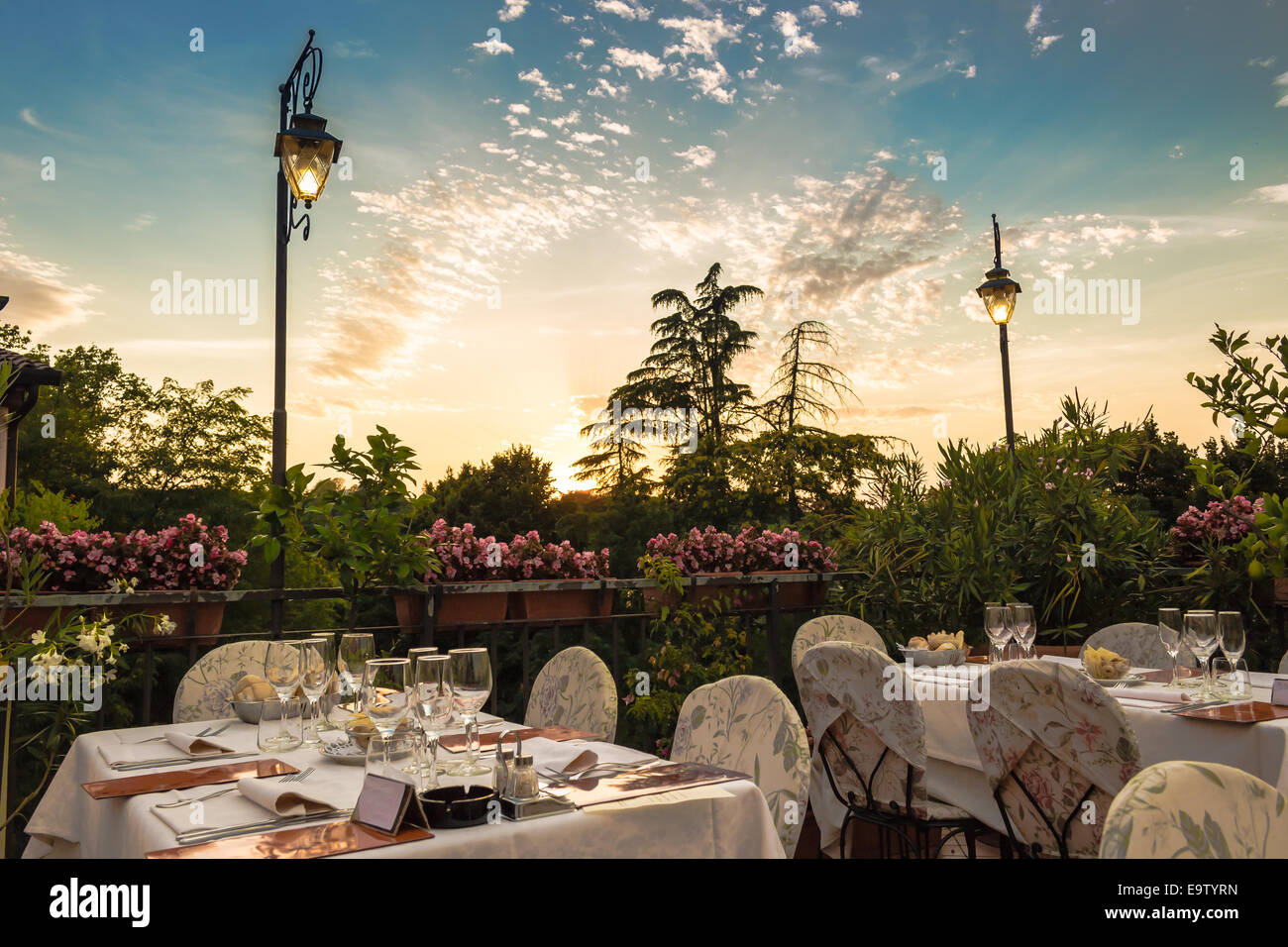 Tables de dîner dans l'élégant restaurant italien de style outdoor sur caillebotis fer parapet sur les collines de Dozza (Bo) en Italie dans une journée ensoleillée d'été : du vrai rouge, jaune et fleurs roses avec des feuilles vertes en pots vert tout autour. Serviettes de table Nappe rose et chic, Banque D'Images Tables de dîner dans l'élégant restaurant italien de style outdoor sur caillebotis fer parapet sur les collines de Dozza (Bo) en Italie dans une journée ensoleillée d'été : du vrai rouge, jaune et fleurs roses avec des feuilles vertes en pots vert tout autour. Serviettes de table Nappe rose et chic, Banque D'Images
