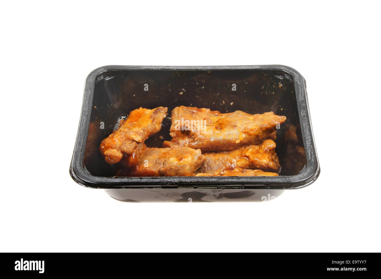 Côtes levées de porc à la chinoise dans un bac en plastique blanc isolé contre Banque D'Images