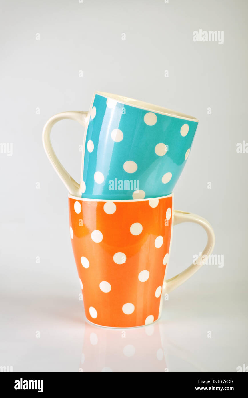 Polka Dot vides empilées, tasses tasse bleu et orange Banque D'Images