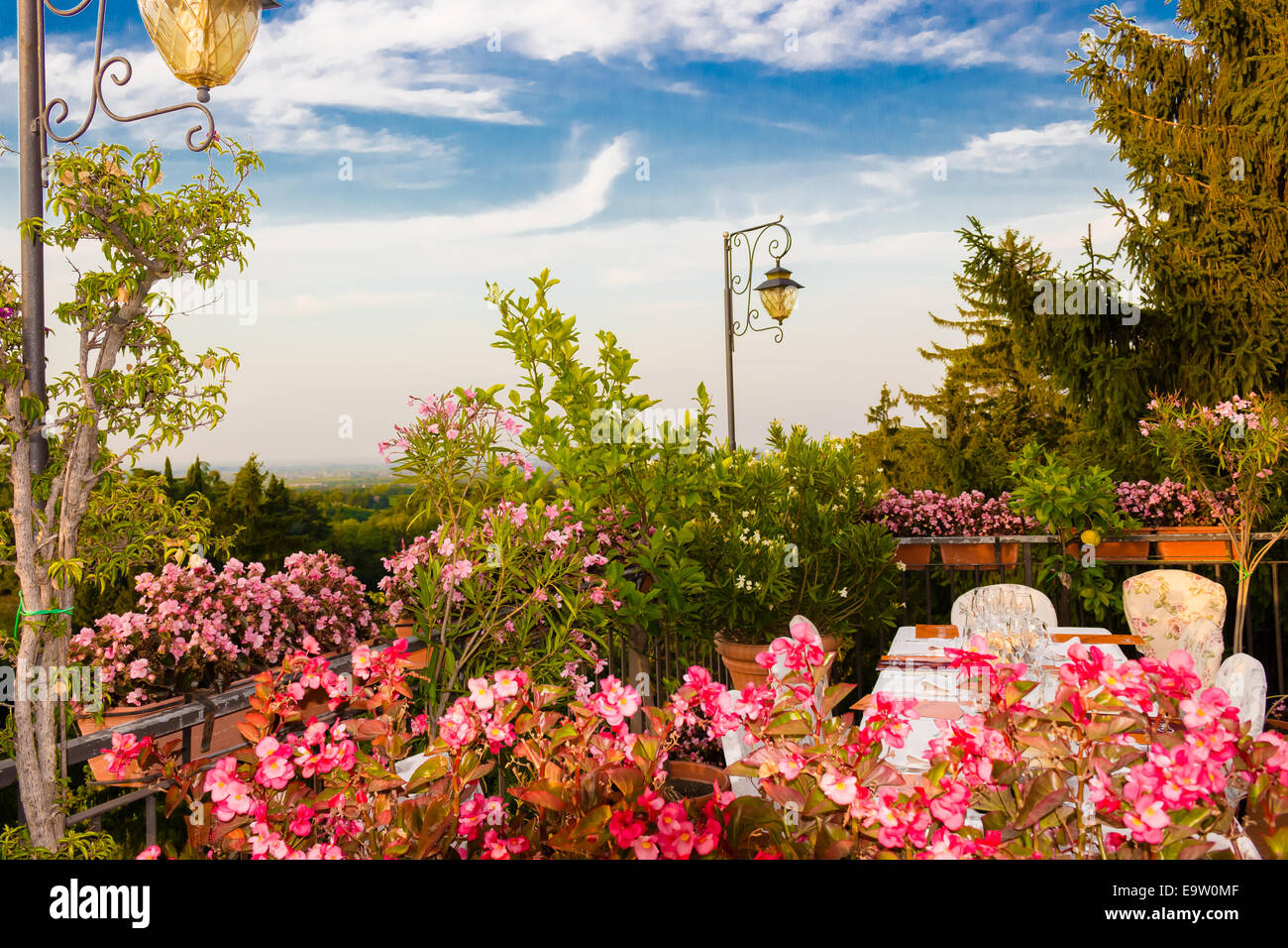 Tables de dîner dans l'élégant restaurant italien de style outdoor sur caillebotis fer parapet sur les collines de Dozza (Bo) en Italie dans une journée ensoleillée d'été : du vrai rouge, jaune et fleurs roses avec des feuilles vertes en pots vert tout autour. Serviettes de table Nappe rose et chic, Banque D'Images Tables de dîner dans l'élégant restaurant italien de style outdoor sur caillebotis fer parapet sur les collines de Dozza (Bo) en Italie dans une journée ensoleillée d'été : du vrai rouge, jaune et fleurs roses avec des feuilles vertes en pots vert tout autour. Serviettes de table Nappe rose et chic, Banque D'Images