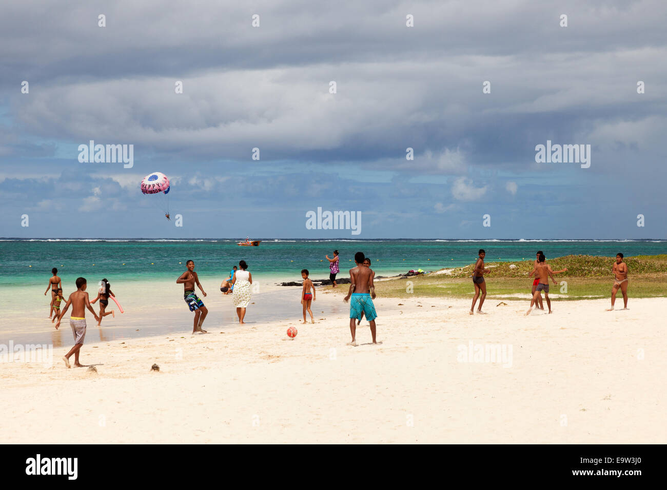 Les enfants mauriciens et les adolescents jouent au football sur la plage, plage de Belle Mare, sur la côte est, dans l'Ile Maurice Banque D'Images