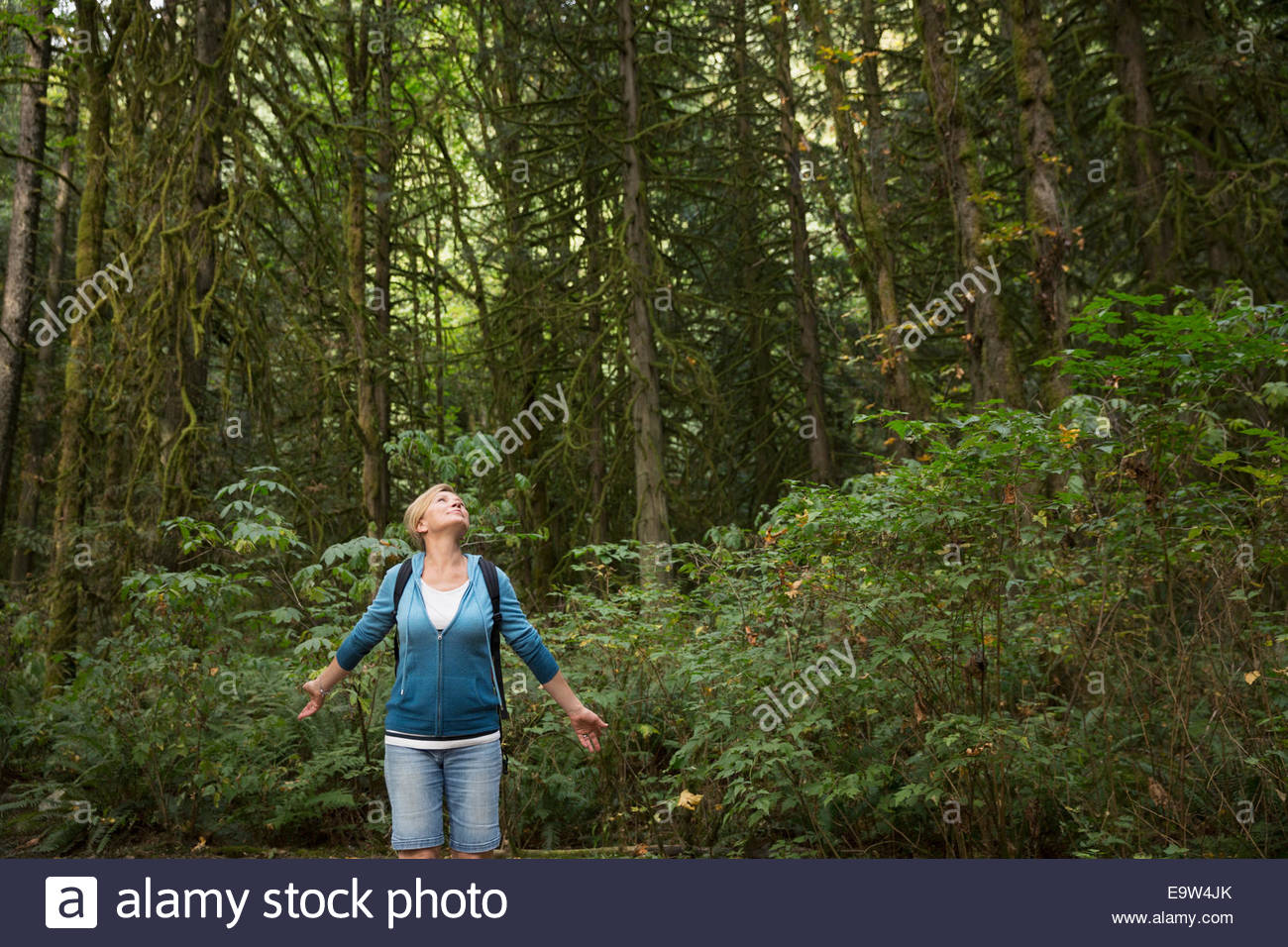 Woman with arms outstretched in woods Banque D'Images