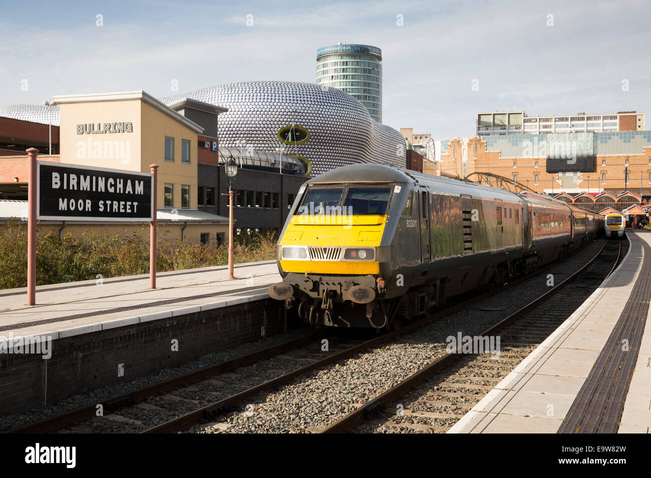 Un train part de Birmingham Moor Street Station, derrière sont,Selfridges, Rotunda et l'Arène Banque D'Images