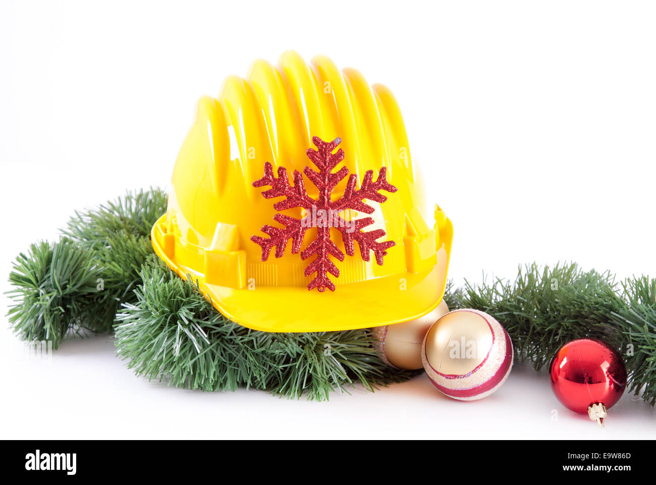 Casque de construction jaune et décoration de Noël sur fond blanc Banque D'Images