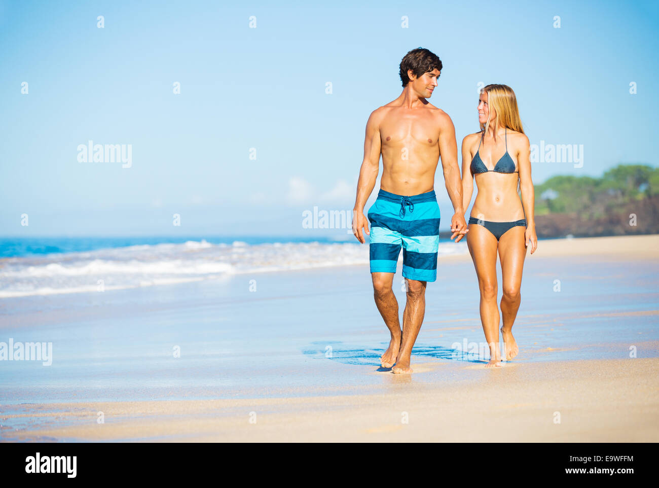 Belle heureux Couple marchant sur la plage de sable Banque D'Images