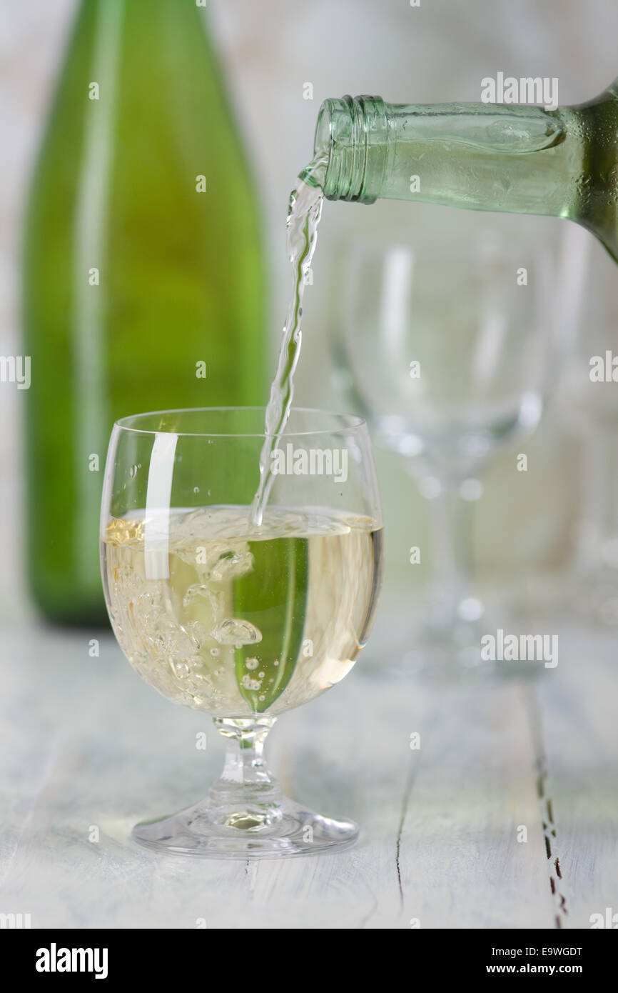 Le vin blanc est versé dans un verre. Banque D'Images