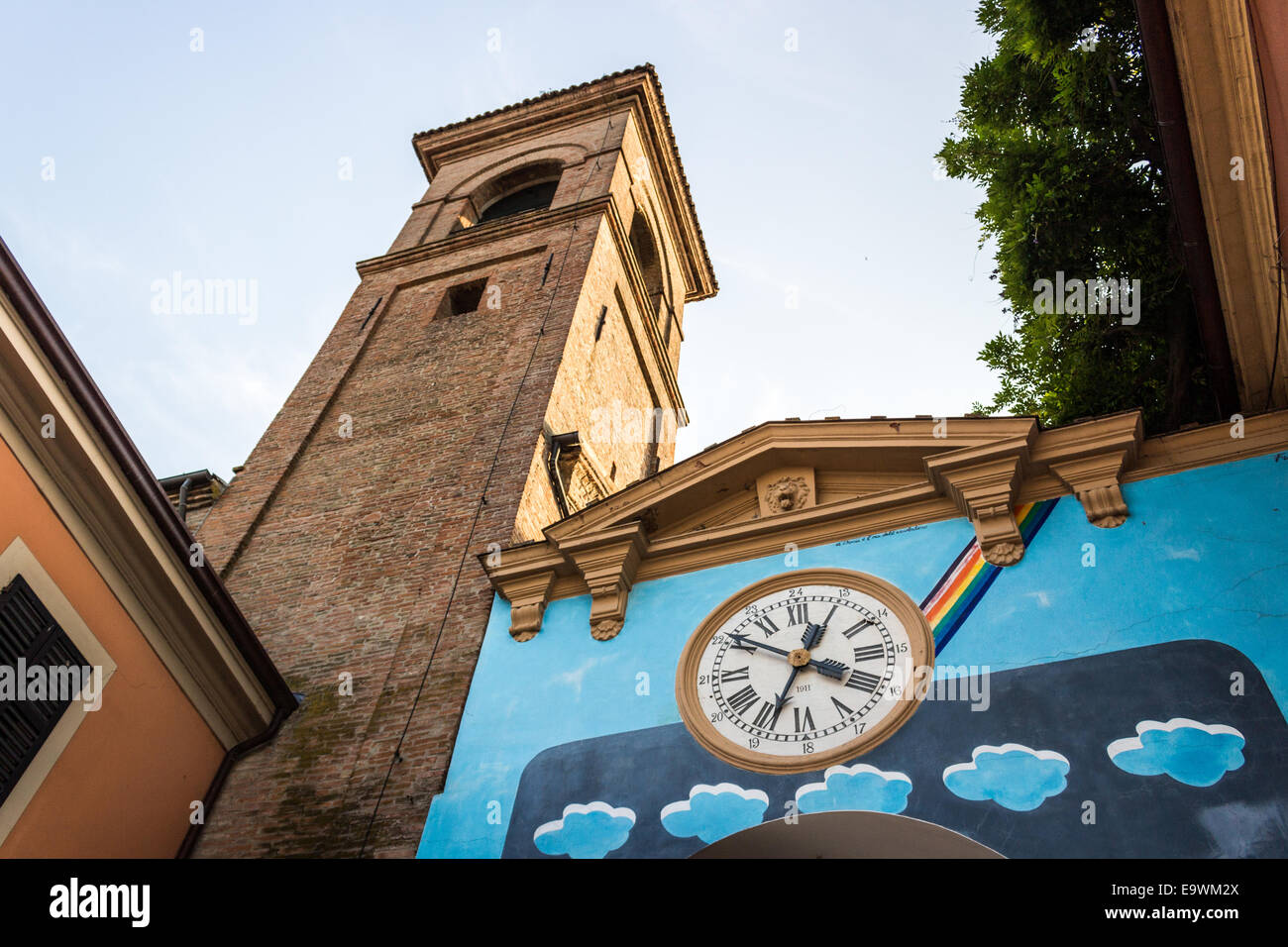 Œuvres d'équilibre peint sur le mur des maisons du petit village médiéval de Dozza près de Bologne en Émilie-Romagne, Italie. Vieille horloge au milieu. Banque D'Images