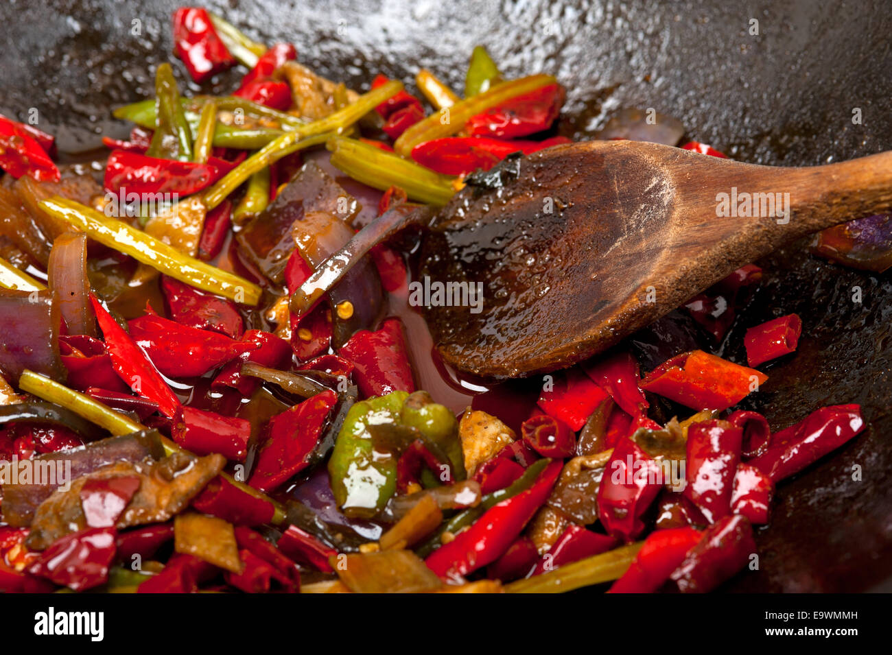 Piment et légumes frits sur un pan wok en fer Banque D'Images