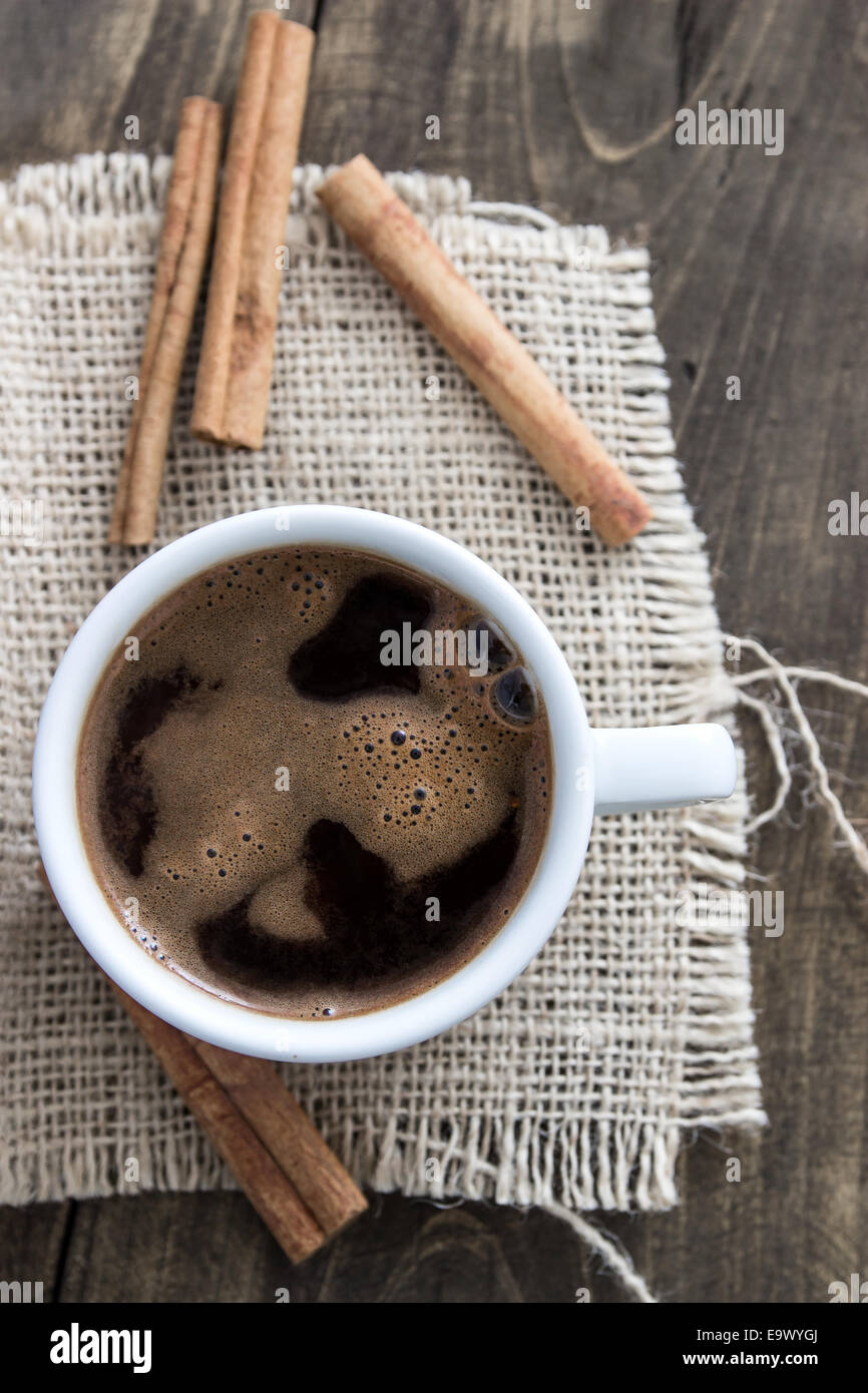 Tasse de café avec des bâtons de cannelle sur le bois, style rustique Banque D'Images