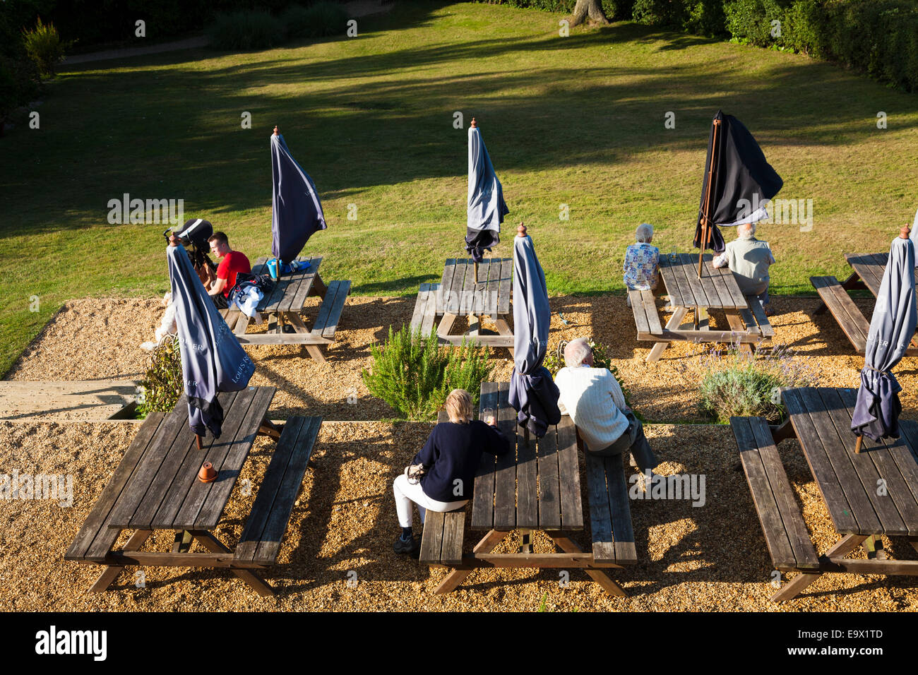 Regardant vers le bas sur les gens assis à des tables banc pub dans la lumière du soleil du soir Banque D'Images