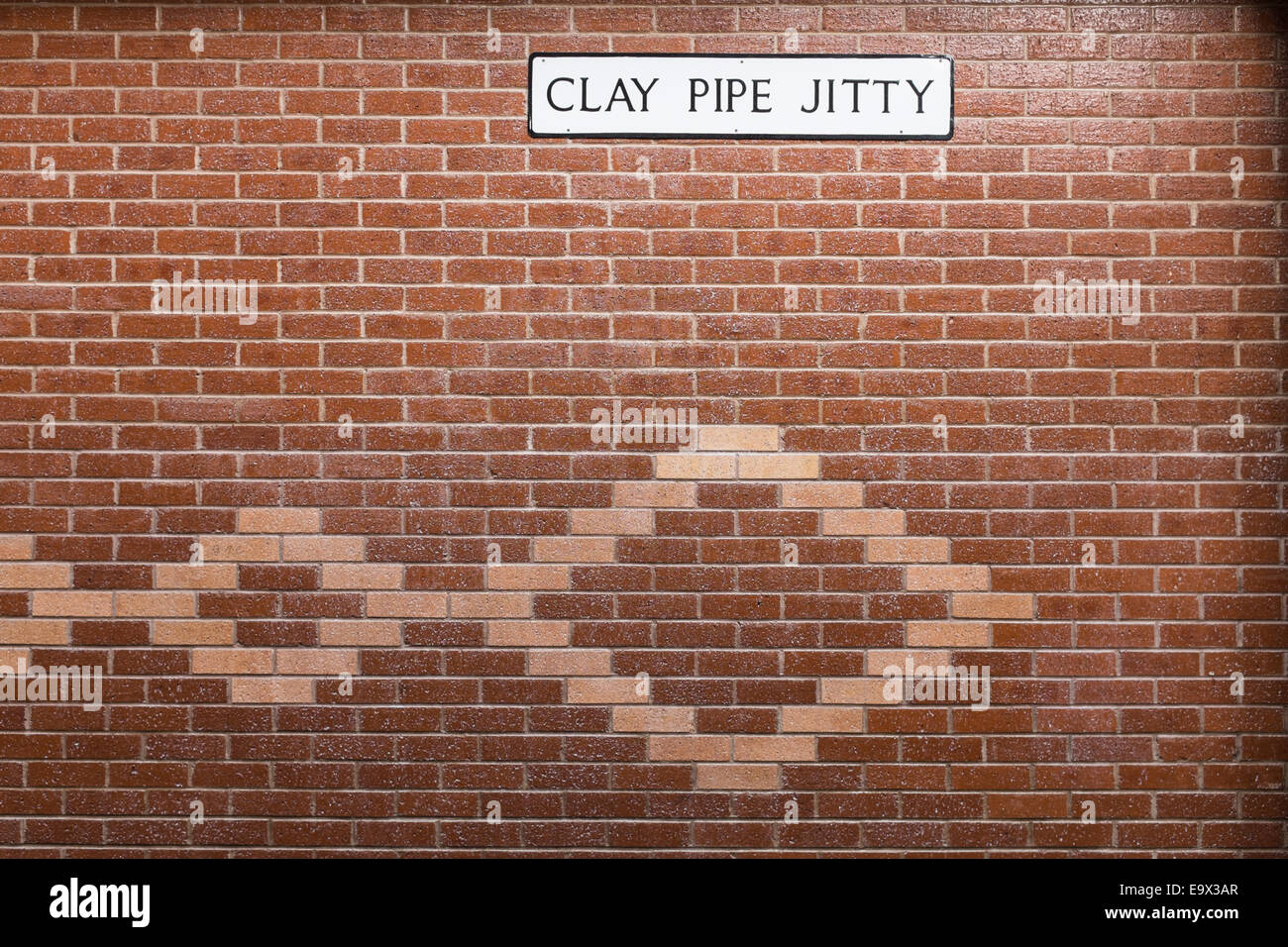 Mur de briques avec inserts décoratifs à motifs en brique et un étrange nom de rue signe pipe en argile jitty'. Banque D'Images