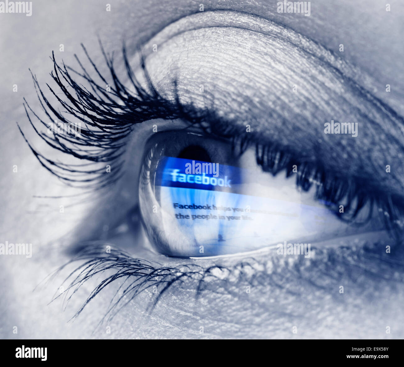 Libre d'une jeune femme avec des yeux bleu logo de Facebook reflétant en elle. Noir et blanc avec blue Banque D'Images