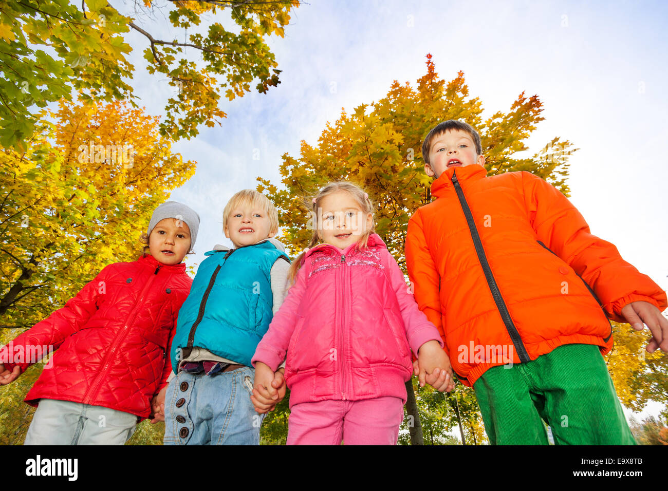 Enfants heureux dans vestes colorées Standing together Banque D'Images