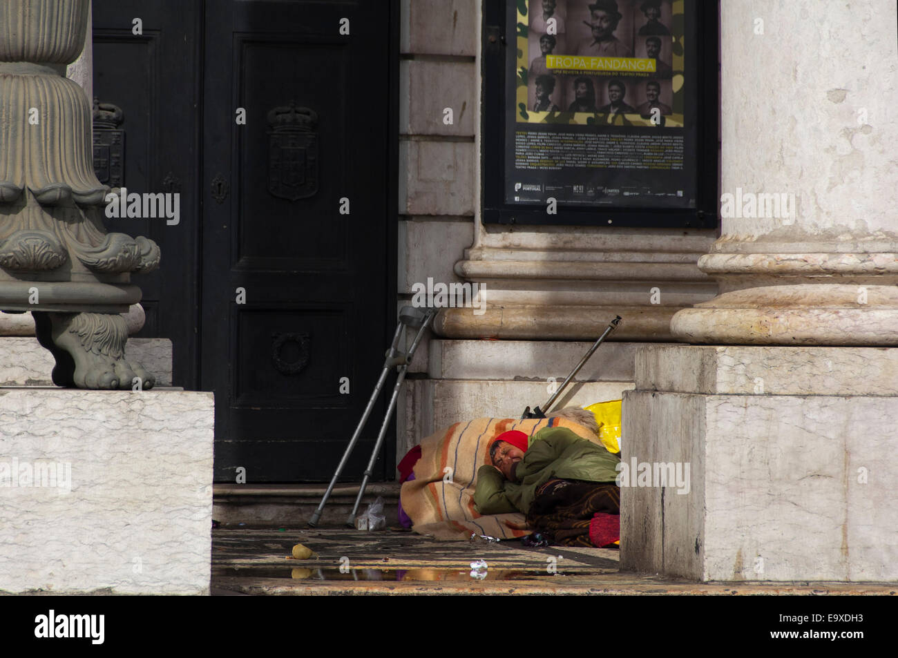 Portrait horizontal d'un rough sleeper pose dans l'entrée du Théâtre National D. Maria II à Lisbonne. Banque D'Images