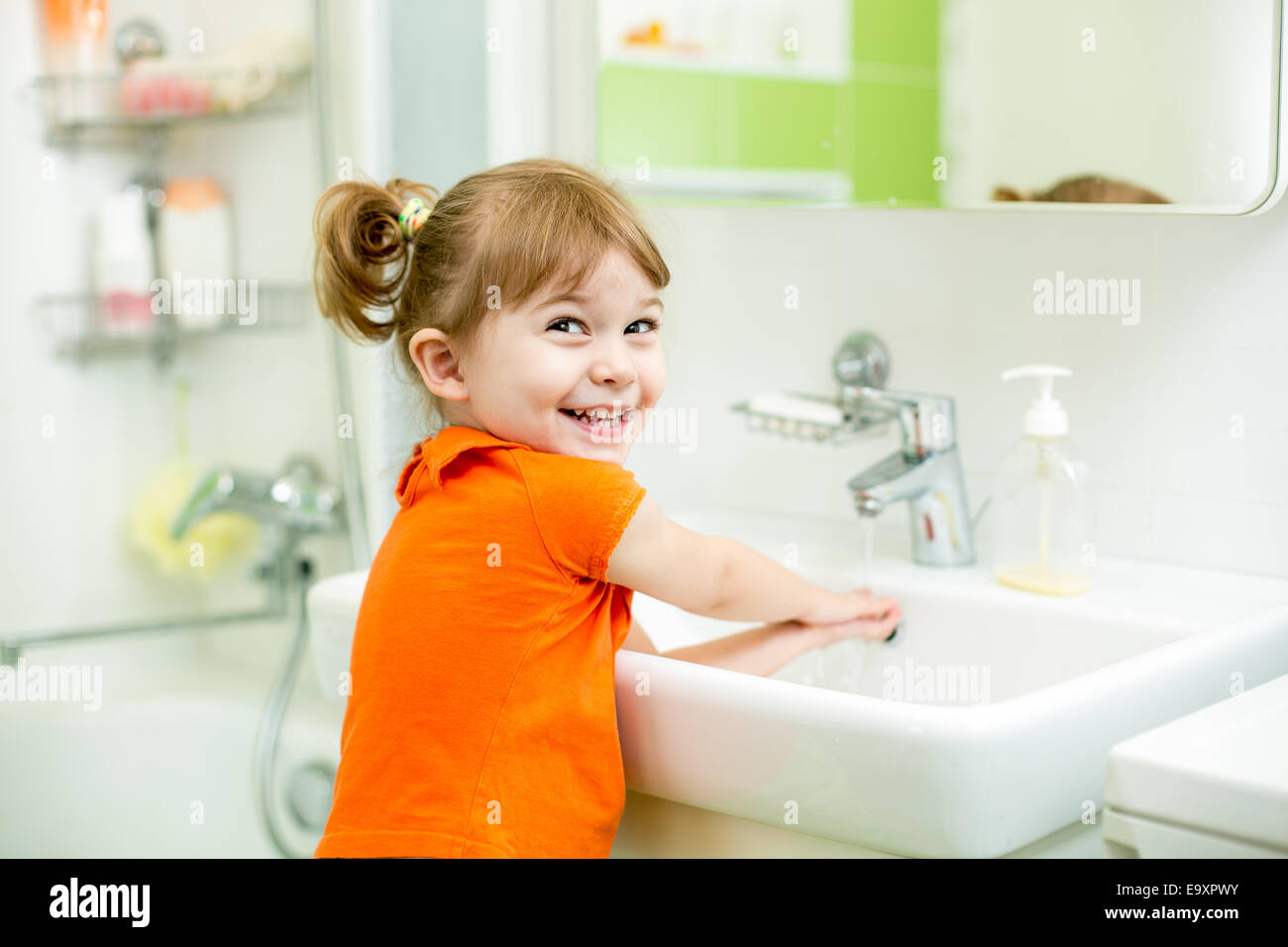 Cute kid girl washing dans salle de bains Banque D'Images