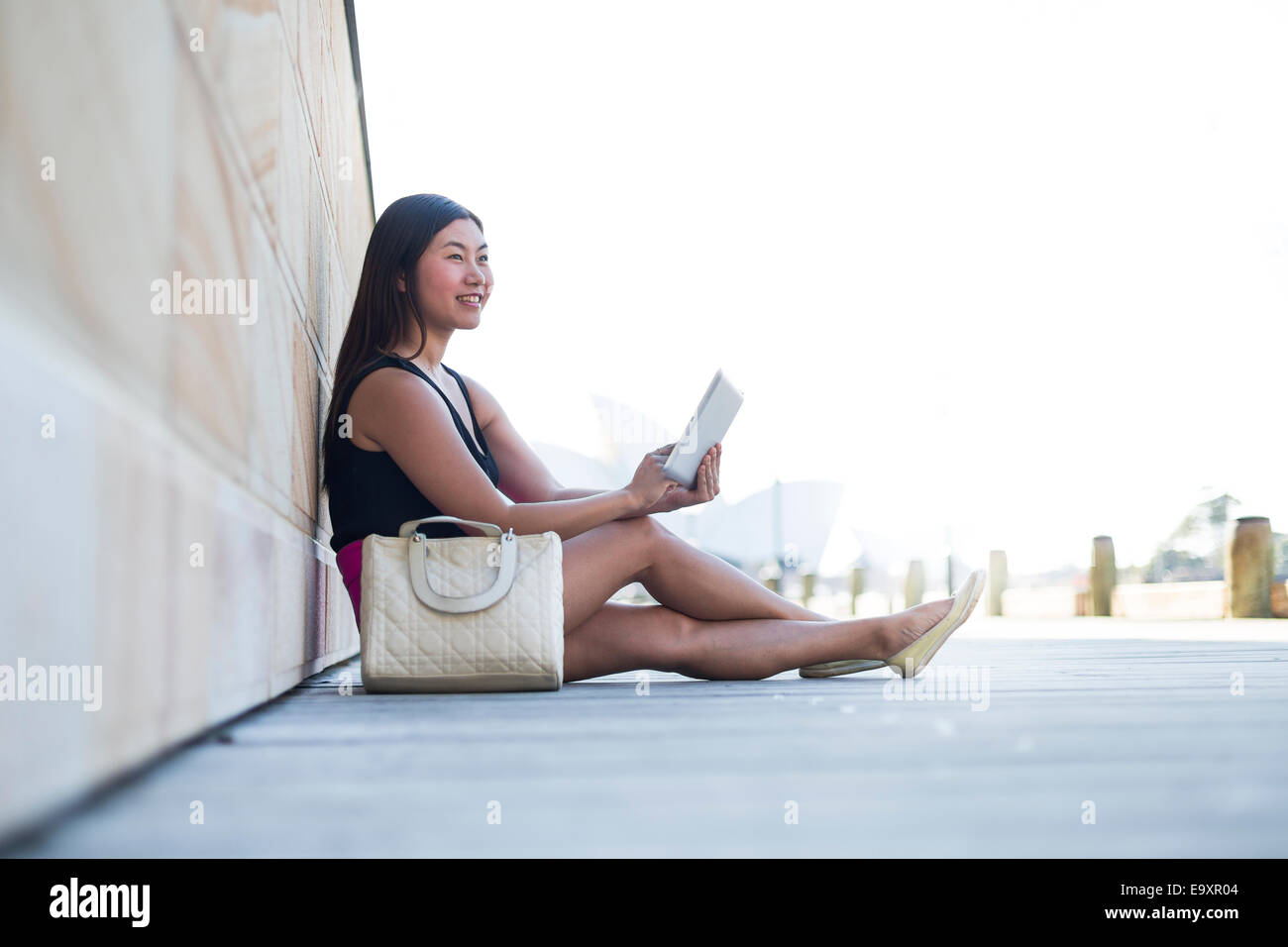Une jeune femme se détendre en regardant le contenu sur une tablette Banque D'Images