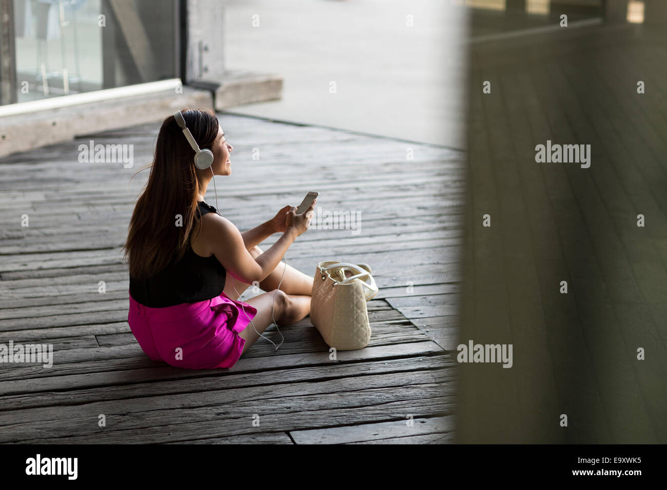 Une jeune femme asiatique consommation du contenu sur son smartphone outdoors Banque D'Images