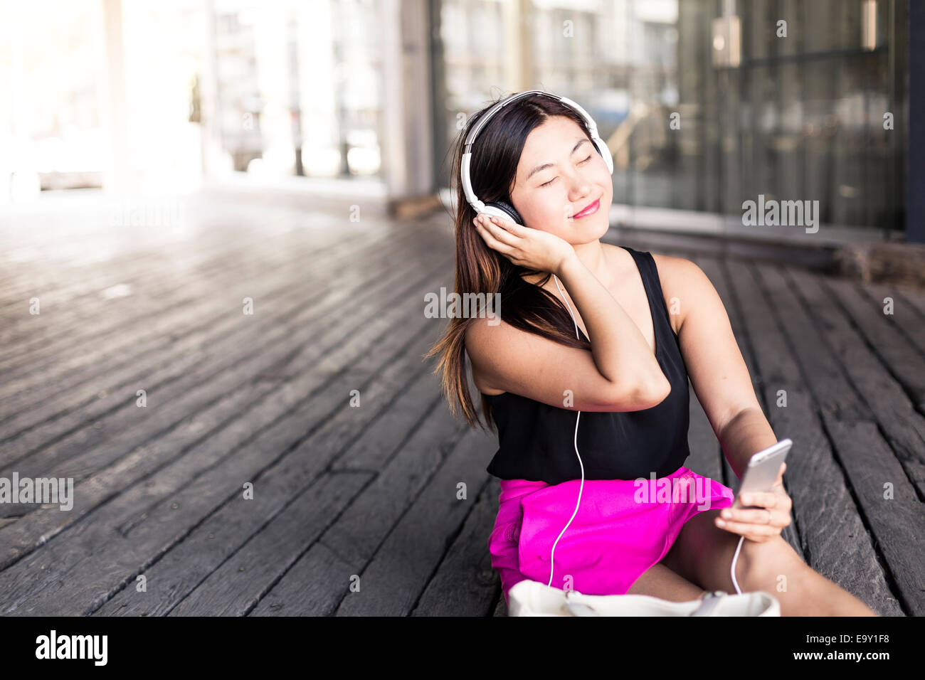 Une jeune femme asiatique en utilisant son périphérique mobile Banque D'Images