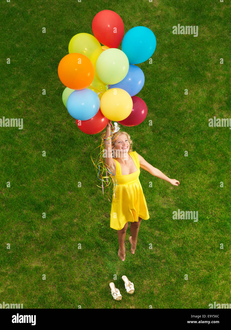 Jeune femme heureuse battant du sol sur des montgolfières colorées Banque D'Images