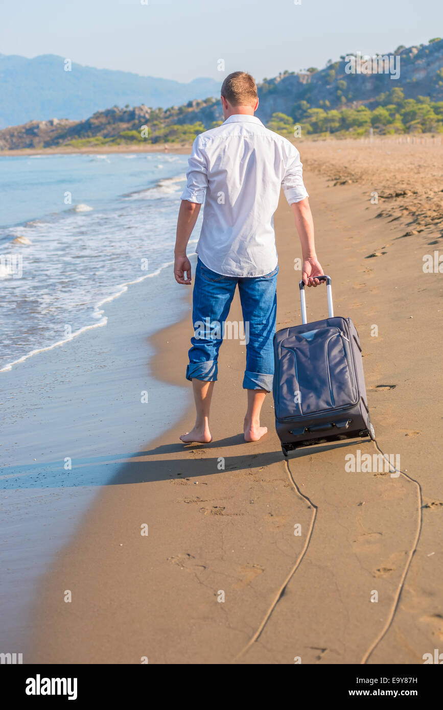 Touristique avec une valise perdue sur une île déserte Banque D'Images