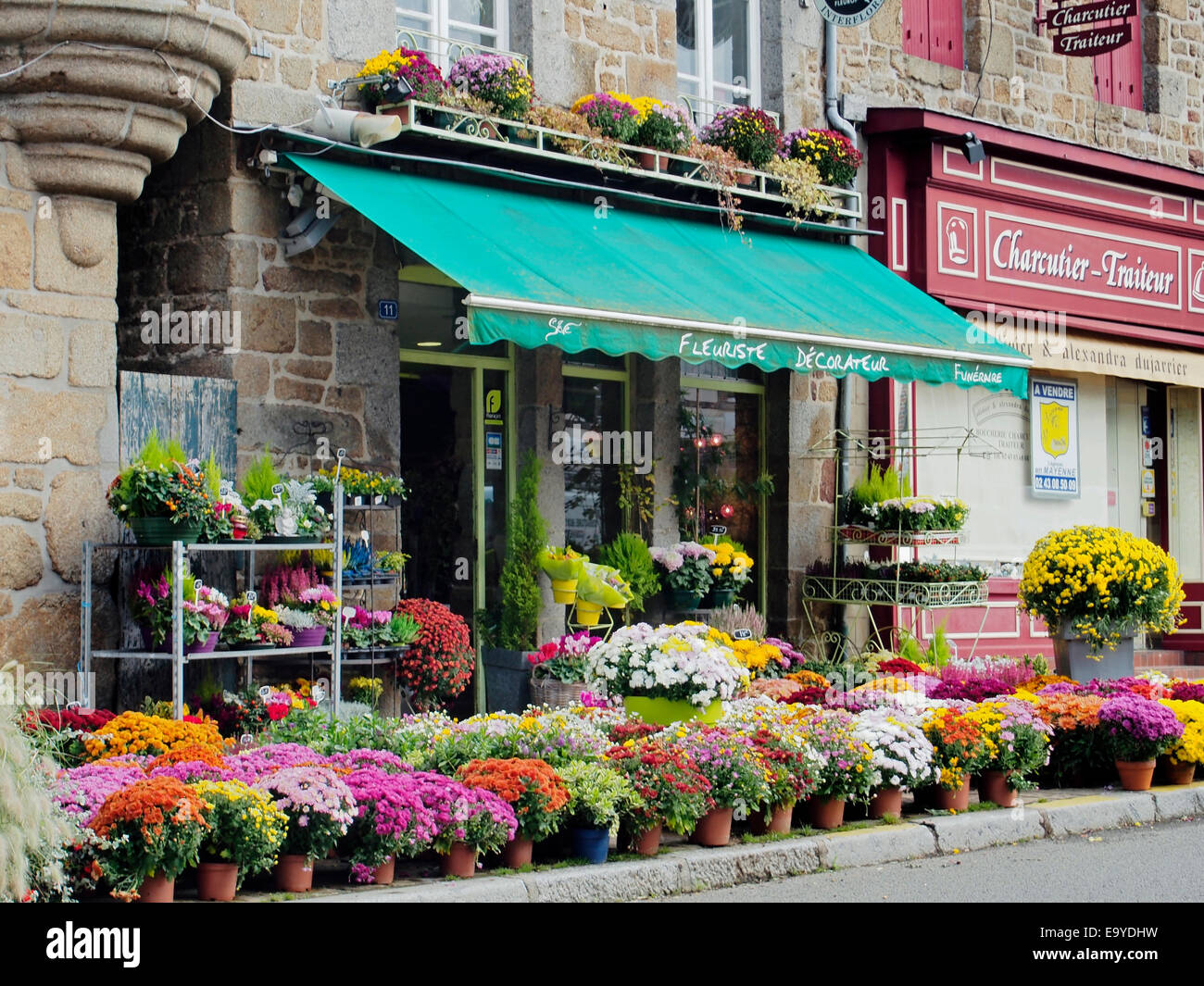 Un magasin de fleur dans un joli bâtiment en pierre sur la place du marché de la petite ville de Lassay-les-Châteaux, Mayenne, France Banque D'Images