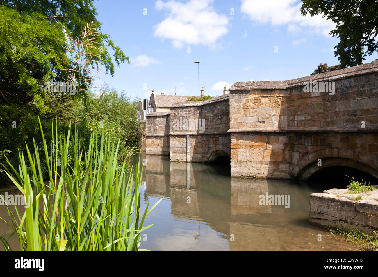 La rivière Windrush coule sous le vieux pont de pierre dans la ville de Cotswold Burford Oxfordshire, UK Banque D'Images