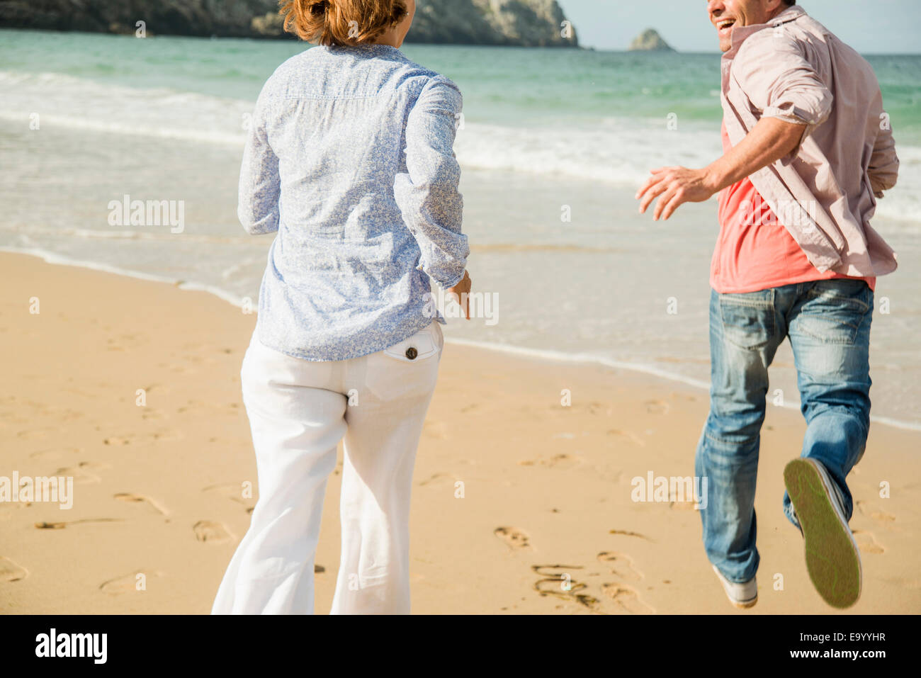 Mature couple running on beach, Camaret-sur-mer, Bretagne, France Banque D'Images