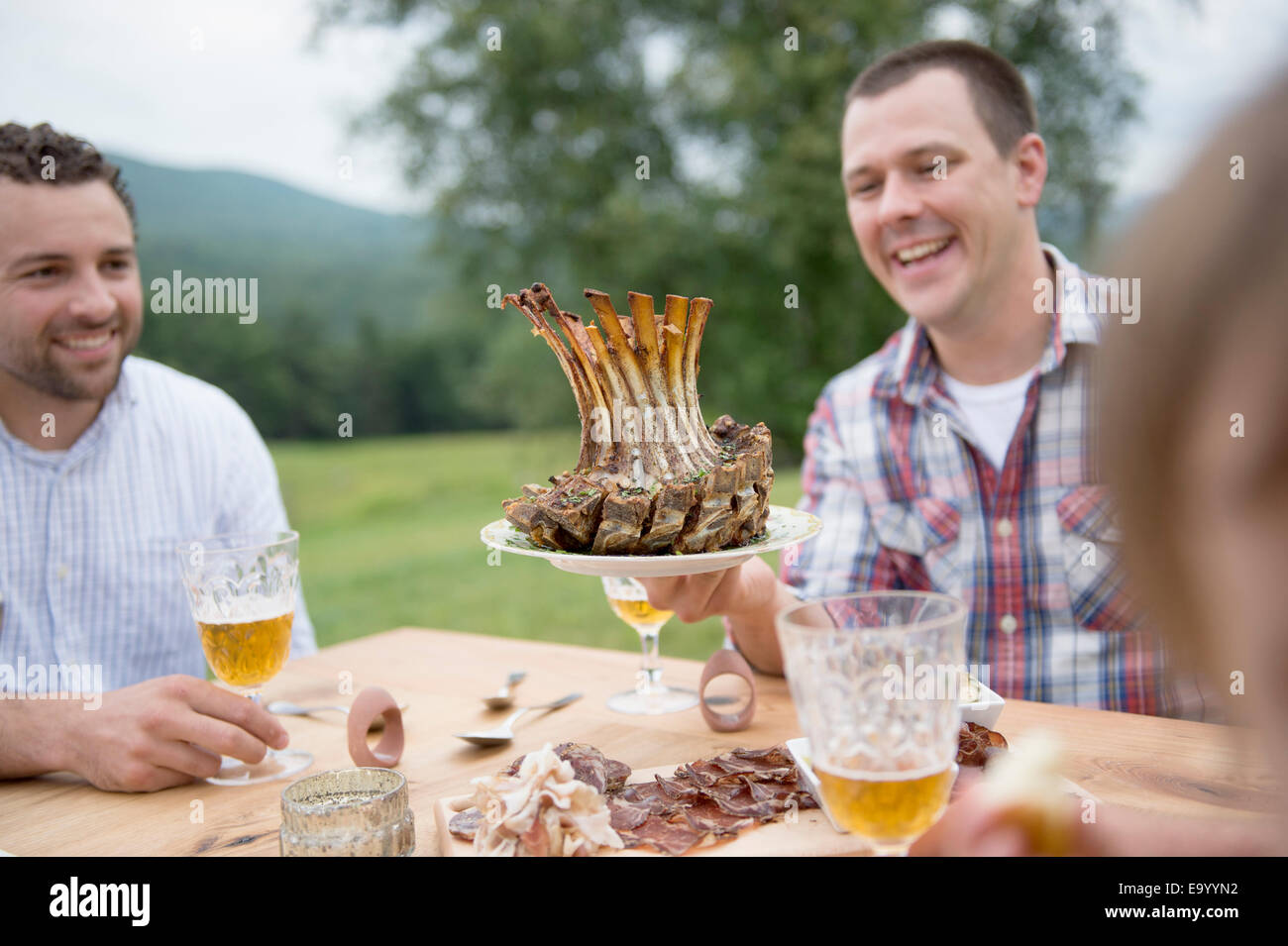 Petit groupe d'adultes enjoying meal, outdoors Banque D'Images