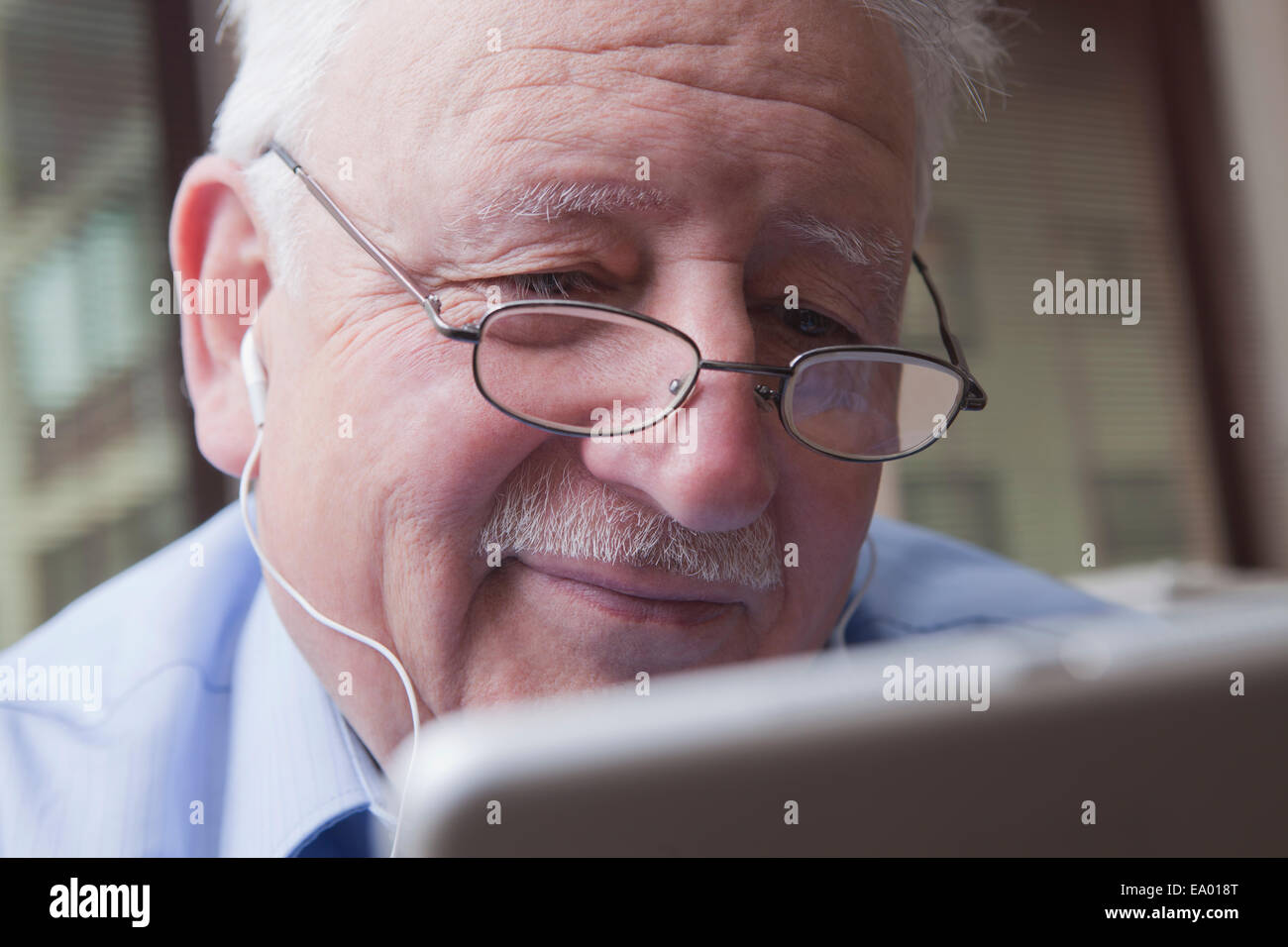 Senior man reading digital tablet Banque D'Images
