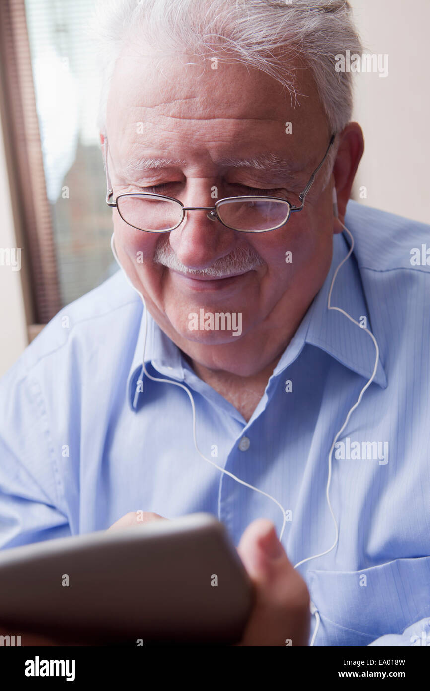 Senior man reading digital tablet Banque D'Images