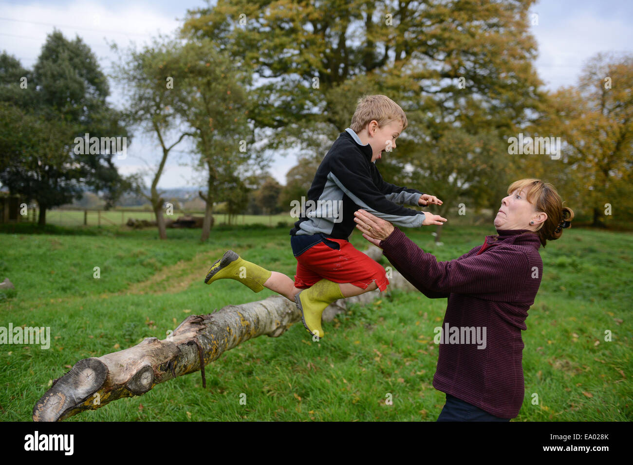 Enfants Enfant Garçon ayant plein air avec grand-mère de sauter dans les bras de confiance confiance modèle britannique publié Banque D'Images