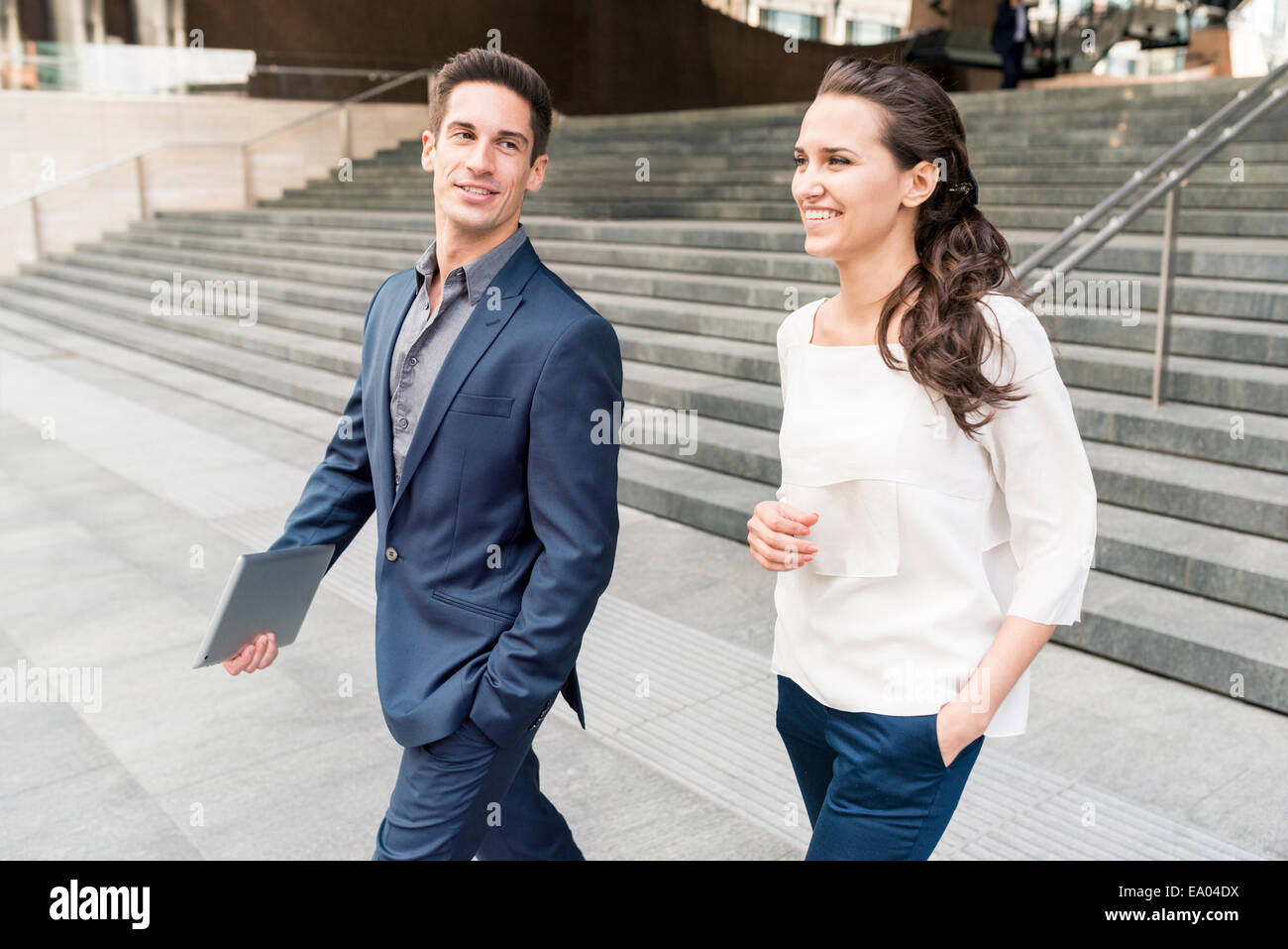 Young businessman and woman chatting en marchant, London, UK Banque D'Images