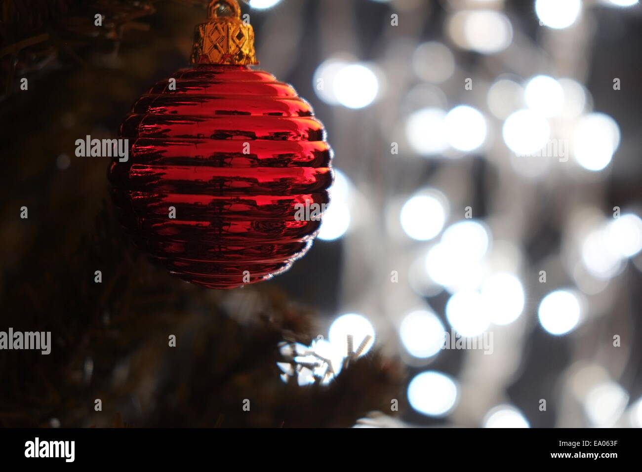 Boule de Noël rouge sur un arbre avec des lumières de Noël Banque D'Images