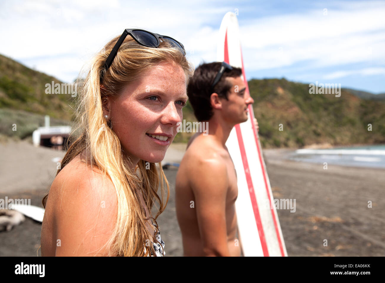 Jeune couple standing on beach looking out to sea Banque D'Images