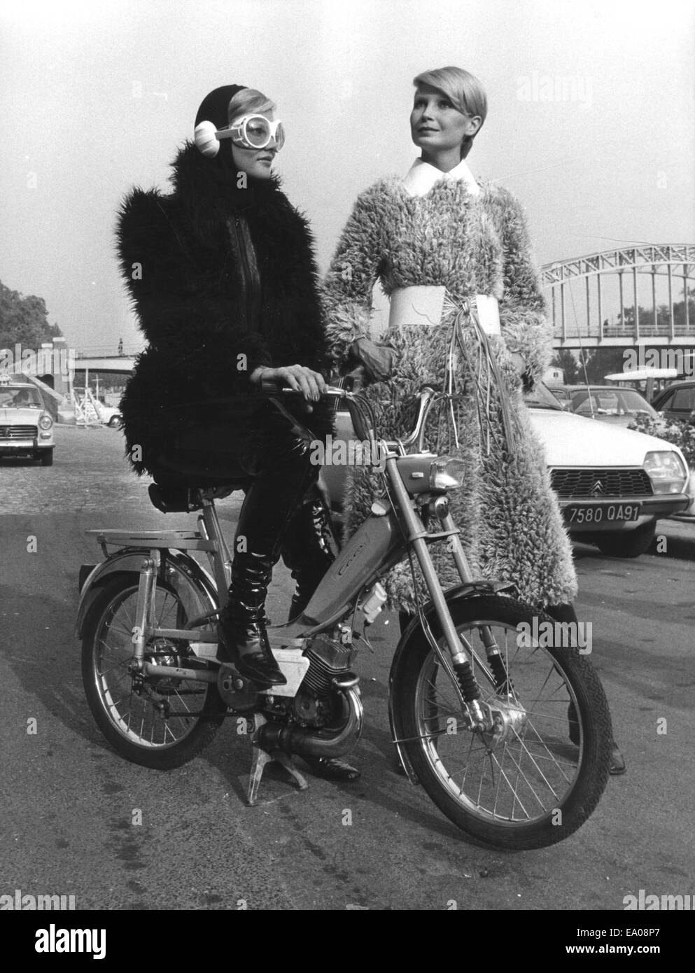 Paris, France. Sep 30, 1971. Crazy manteaux de fourrure provenant d'une collection de fourrure synthétique. La National Association for Textile vient de présenter ses dernières œuvres, fausse fourrure. Les cheveux synthétiques des manteaux d'hiver sont longs et hirsutes à la recherche. Le modèle sur le cyclomoteur portant la veste longue 'Chrysanthème' manteau en imitation de la Mongolie et le modèle Claudine sur droite porte un manteau blanc acrylique avec un Peter Pan col et ceinture blanche correspondante. © Keystone Photos/ZUMA/ZUMAPRESS.com/Alamy fil Live News Banque D'Images