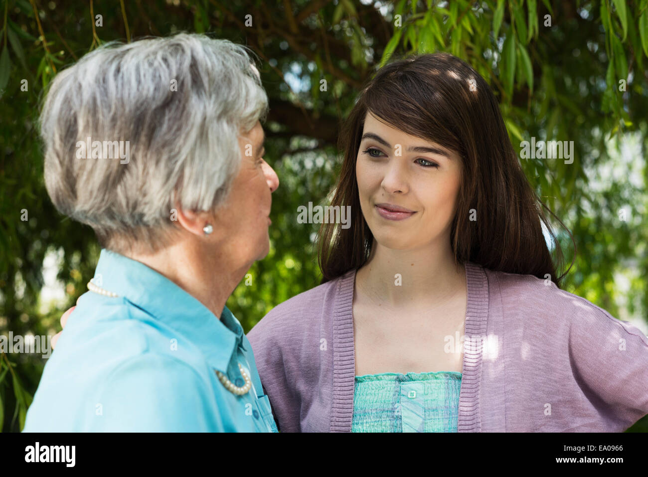 Grand-mère et petite-fille d'avoir conversation dans jardin Banque D'Images