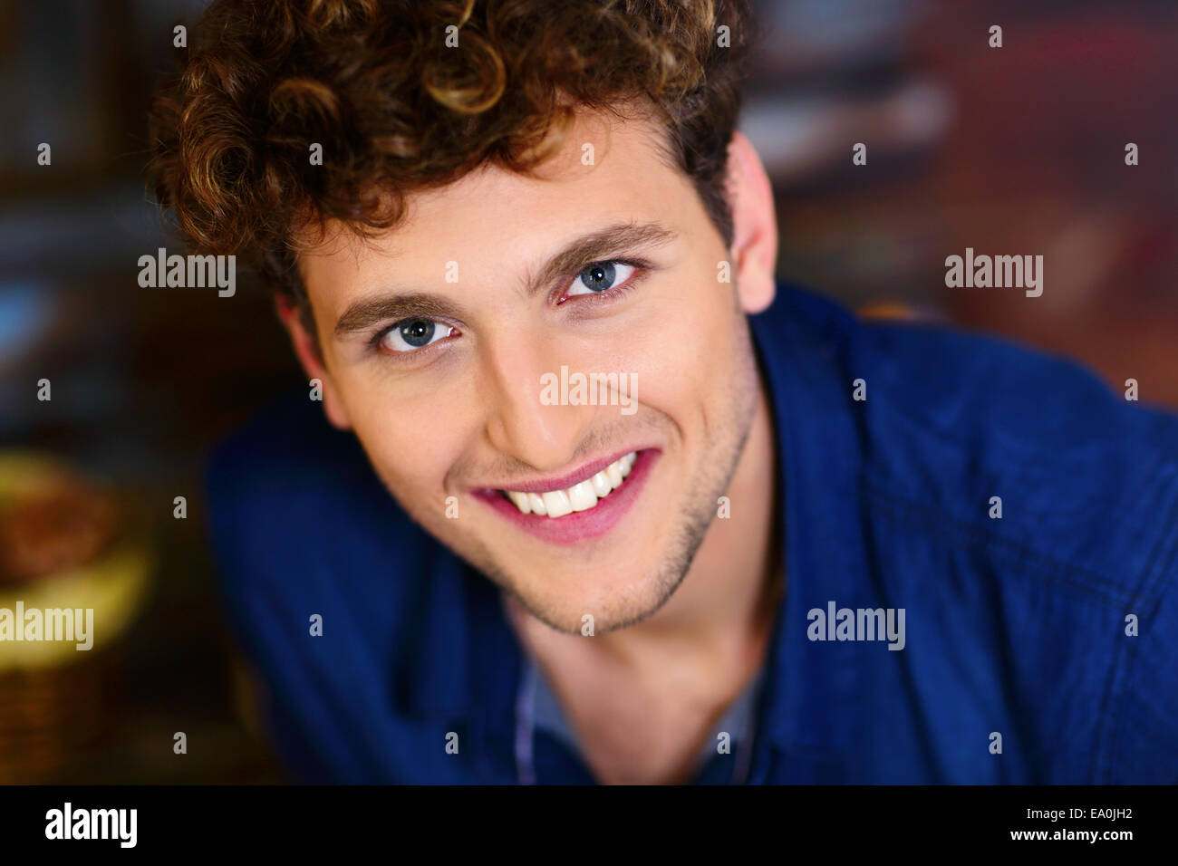 Closeup portrait of a smiling young man avec les cheveux bouclés Banque D'Images