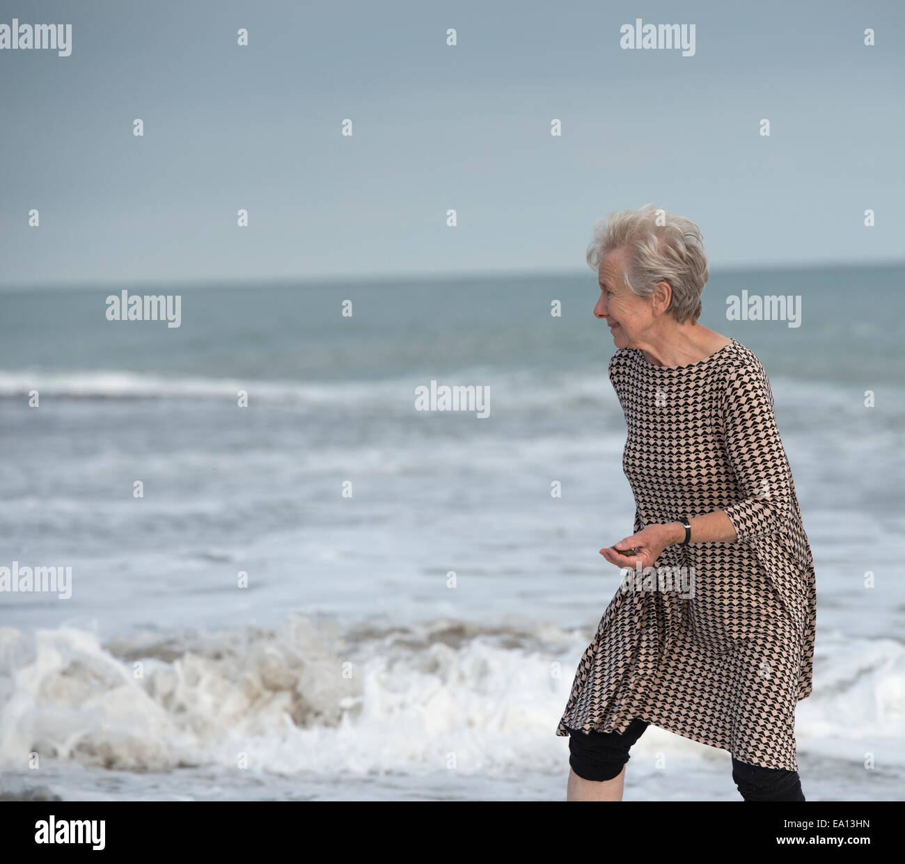 Senior woman running de océan vagues sur la plage, Dana Point, Californie, USA Banque D'Images