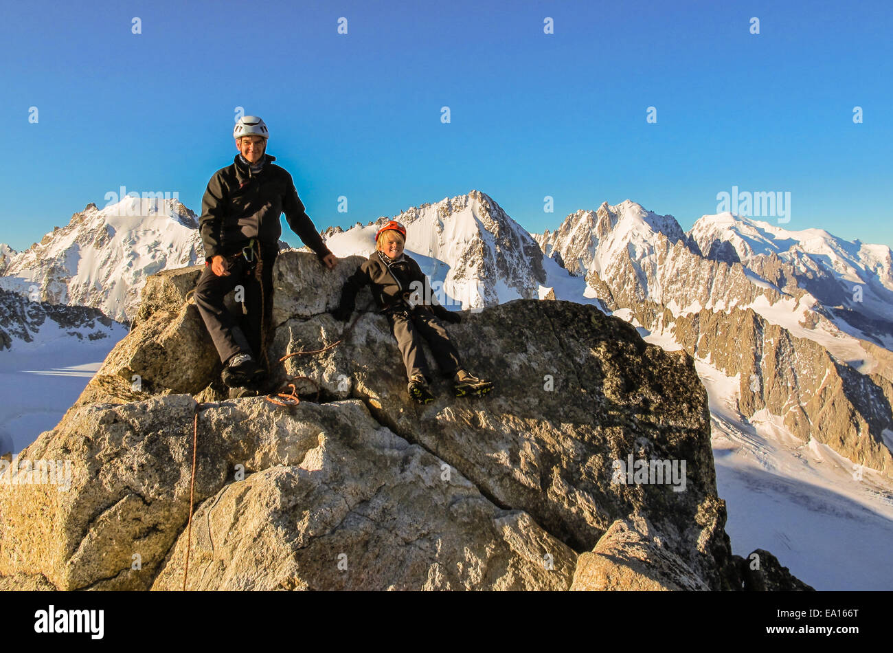 Jeune garçon et son père sur le sommet après avoir gravi l'Aiguille du Tour dans les alpes françaises juste après l'aube. Banque D'Images