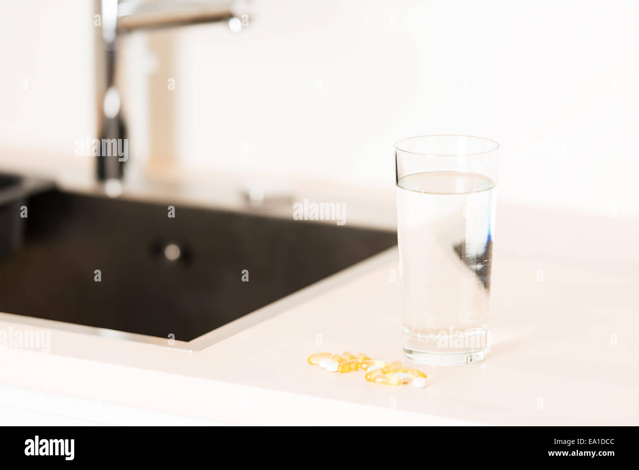 Comprimés et verre d'eau sur un comptoir Banque D'Images